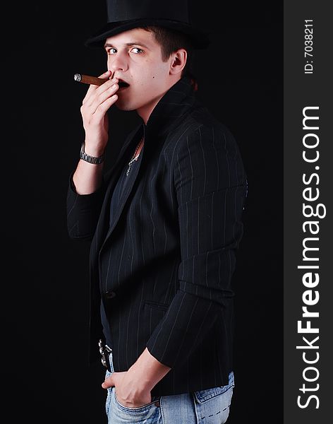 Portrait of young gangster in black suit with cigar. Portrait of young gangster in black suit with cigar