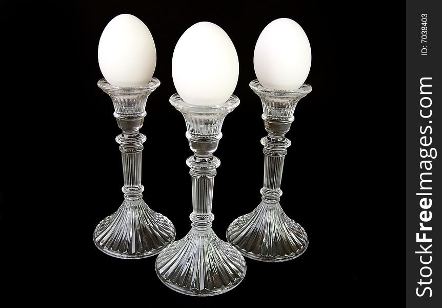 Three eggs on pedestals, full length shot, on a black background. Three eggs on pedestals, full length shot, on a black background