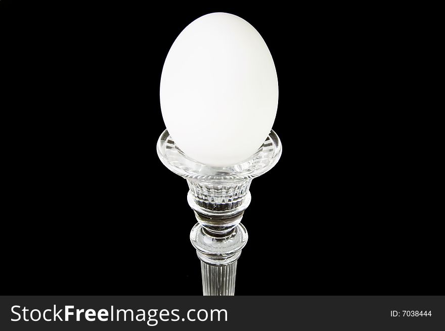 A single egg on a pedestal, on a black background