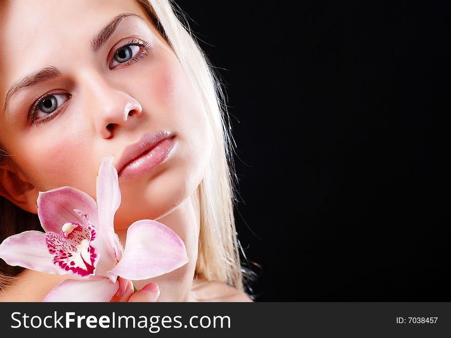 Face of beautiful young woman with delicate orchid. Face of beautiful young woman with delicate orchid