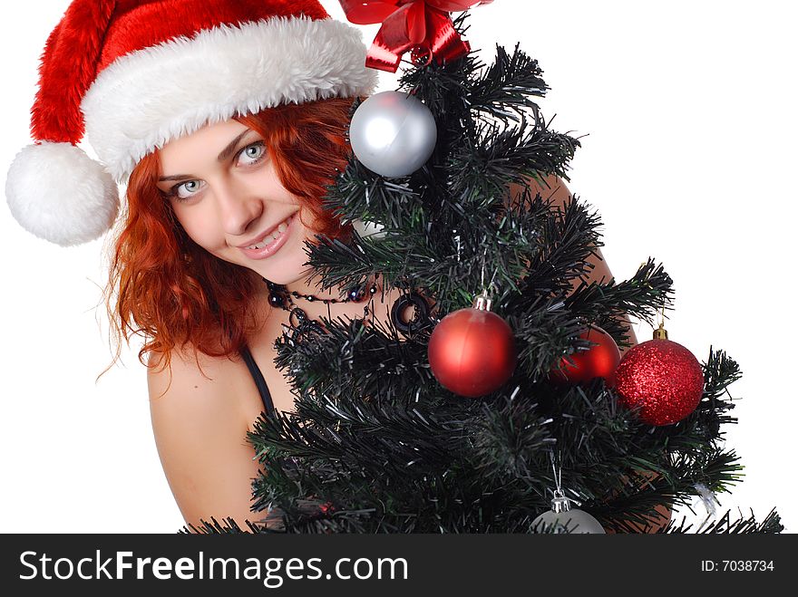 Beautiful woman in a christmas hat with christmas tree. Beautiful woman in a christmas hat with christmas tree