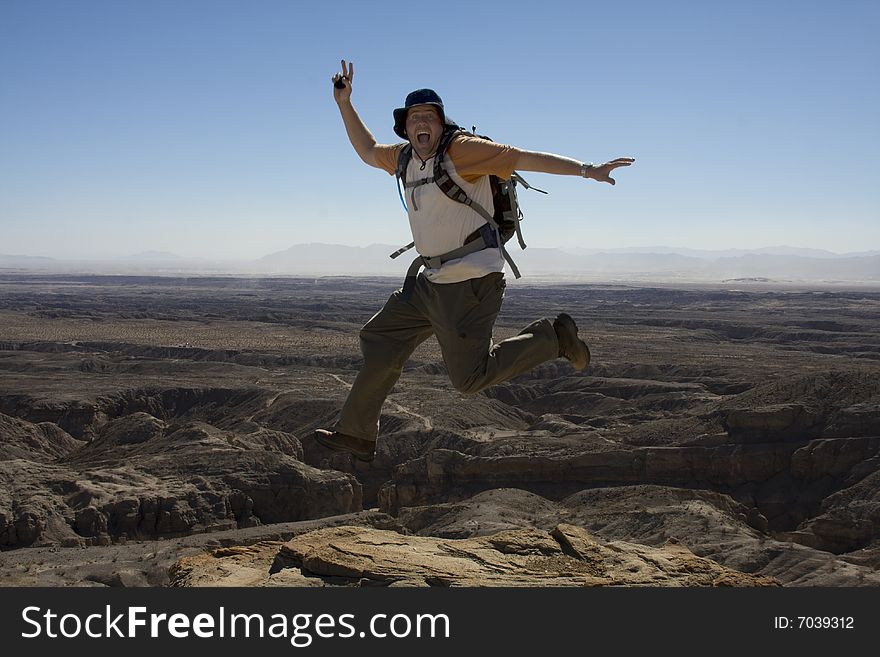 Male Hiker Jumping at an overlook of the Anza-Borrego Desert. Male Hiker Jumping at an overlook of the Anza-Borrego Desert