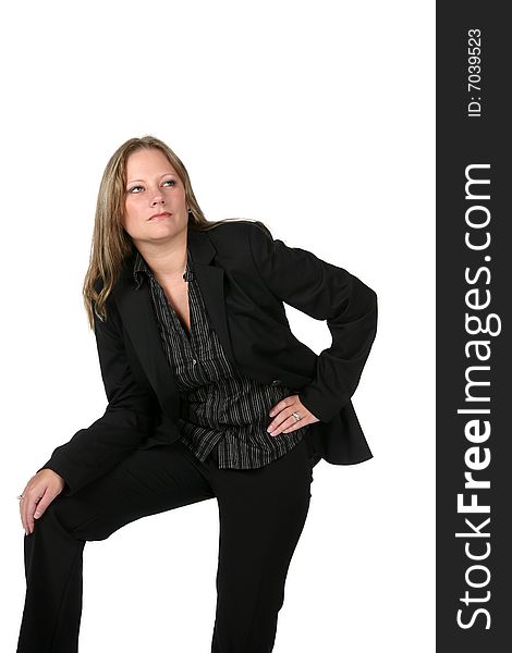 Pretty woman in black business suit with knee up and thoughtful expression on her face