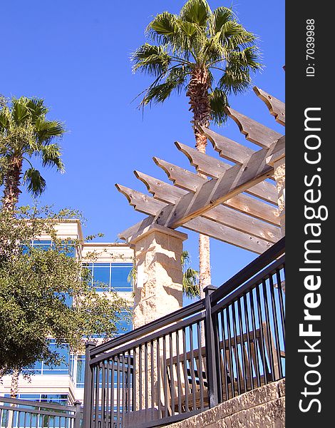 Office building with palm trees and awning.