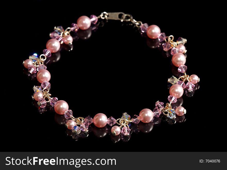 A pink beads bracelet isolated on black background.