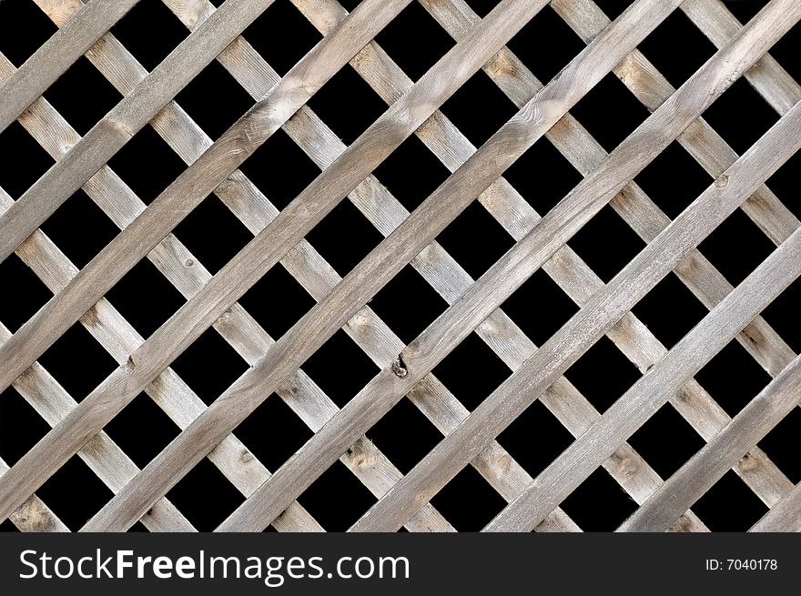 A lattice wooden fence isolated on black. A lattice wooden fence isolated on black.
