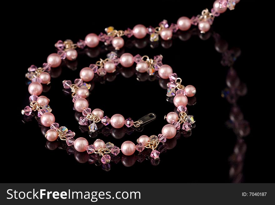 A pink beads necklace isolated on black background.