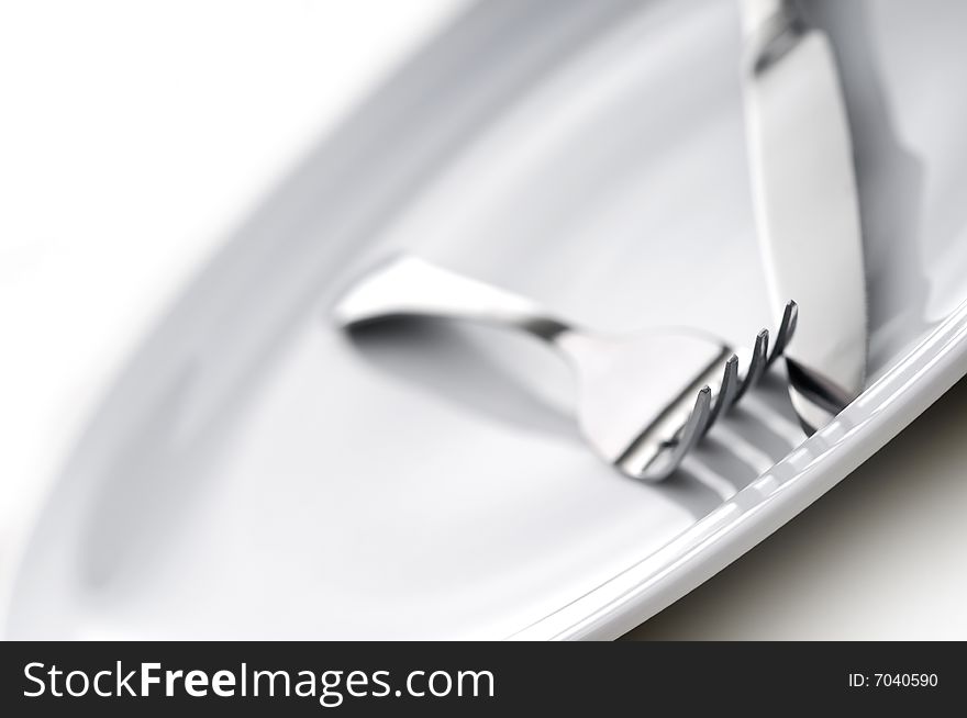 Shallow focus silverware on a white plate