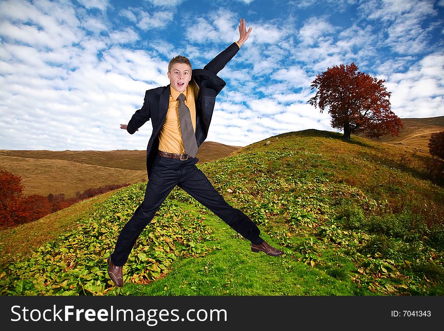 An image of jumping men. Background of hill with tree. An image of jumping men. Background of hill with tree