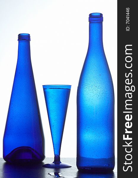 Two dark blue bottles and glass with water