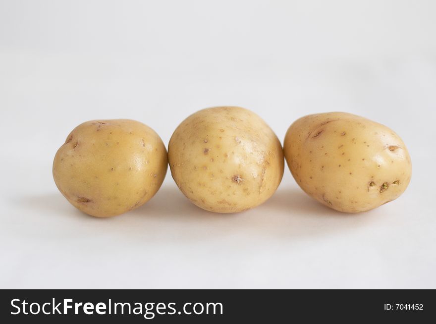Three potatoes abreast on a white background. Three potatoes abreast on a white background