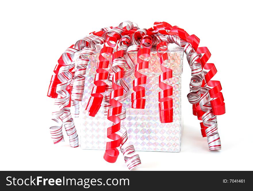 Gift wraped in metallic paper with red, white and silver ribbon isolated on white.