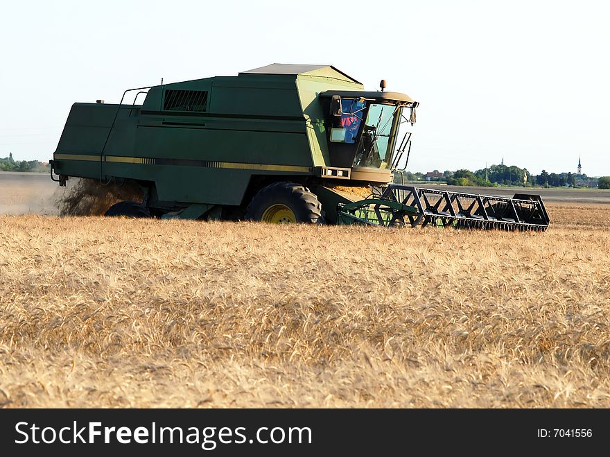 Combine at farmland harvesting cereal plant, outdoor