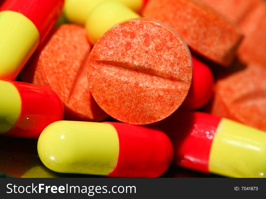 An image of orange pills on green background