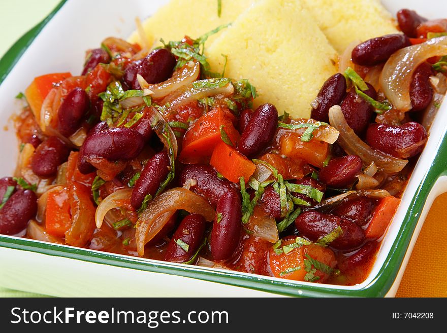 Polenta with stewed vegetable in bowl on table