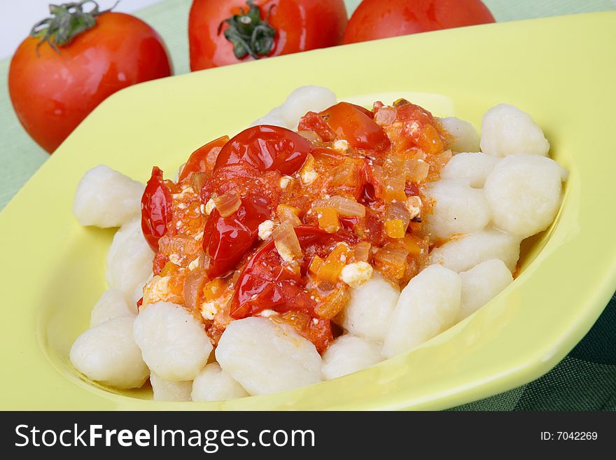 Potato noddles with tomato sauce on plate