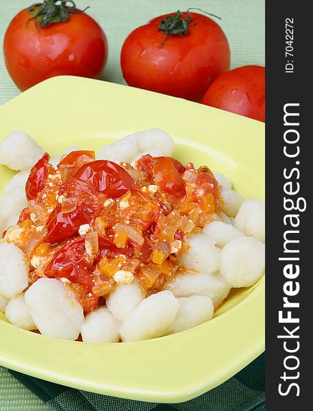 Potato noddles with tomato sauce on plate