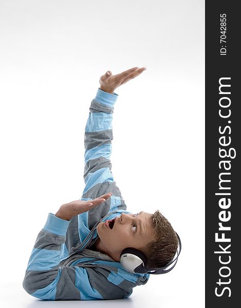 Laying young man with headphone looking upside against white background