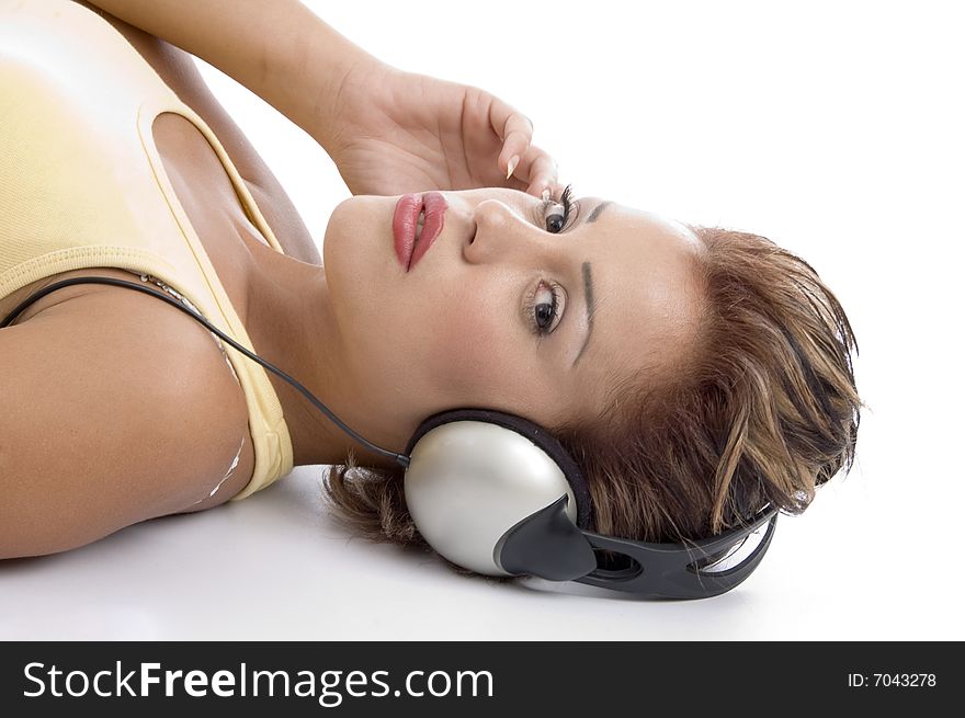 Laying woman with headphone looking at you on an isolated background