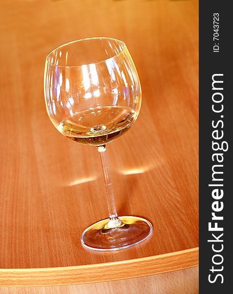Wine glass with wine on orange wood background. Wine glass with wine on orange wood background