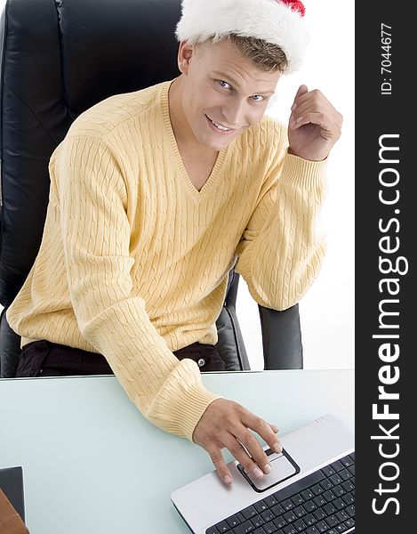 Male wearing Santa hat and working on laptop with white background. Male wearing Santa hat and working on laptop with white background