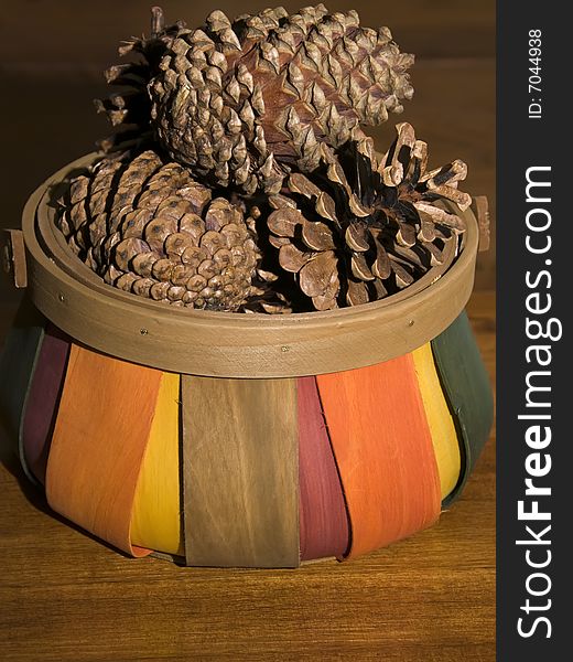 A colorful basket of pine cones. A colorful basket of pine cones.