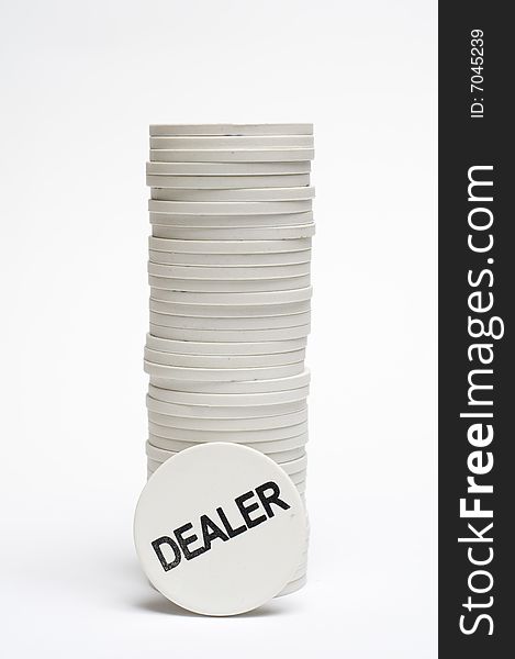 A stack of white casino chips with dealer chip on the base. A stack of white casino chips with dealer chip on the base.