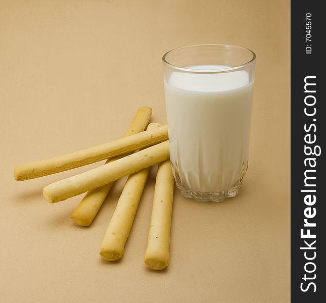 Cakes with milk glass close-up isolated on beige background