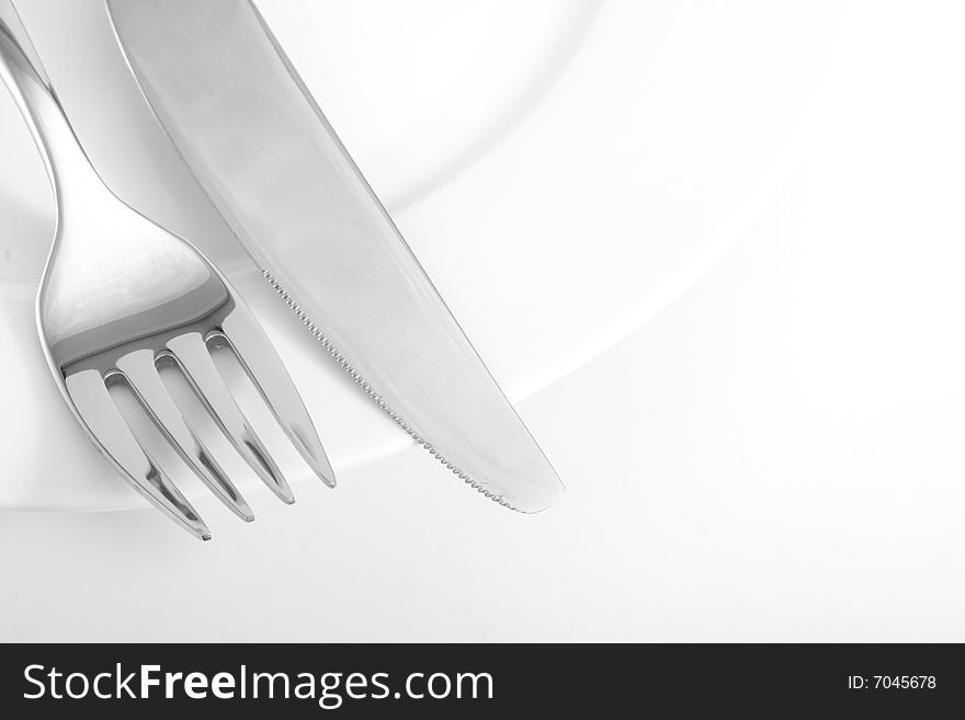 A knife and a fork on a plate. A knife and a fork on a plate