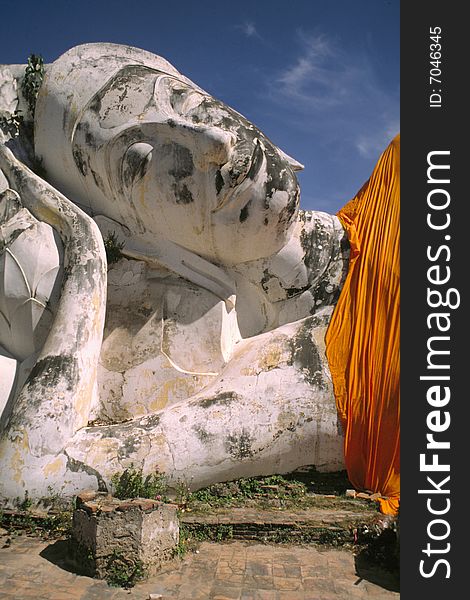 Giant reclining stone Buddha, covered with orange cloth. Ayutthaya, Thailand. Giant reclining stone Buddha, covered with orange cloth. Ayutthaya, Thailand