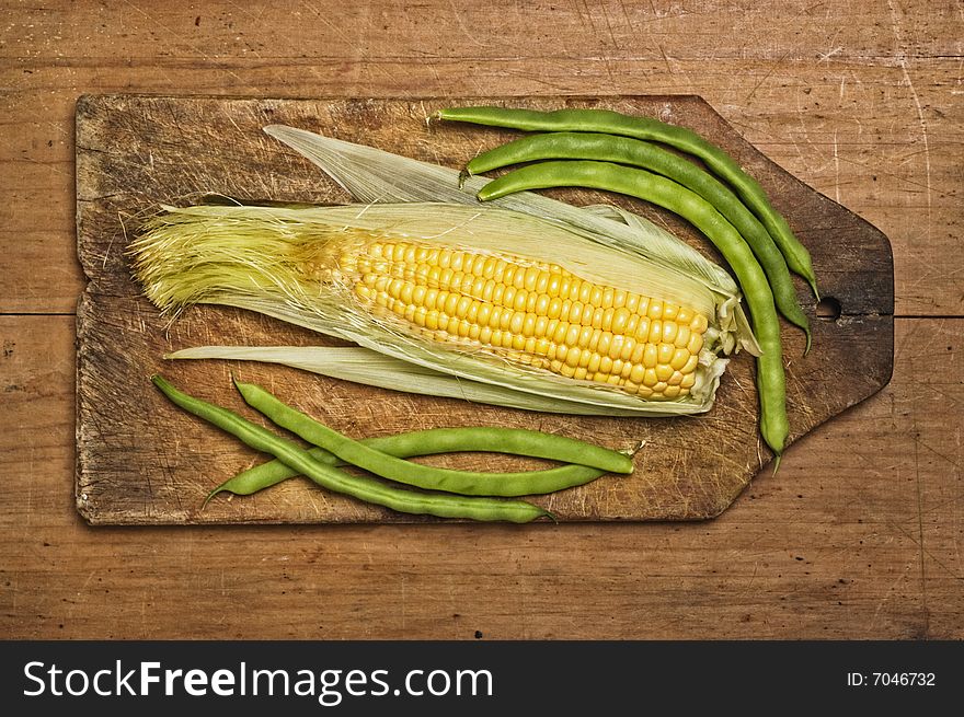 Green beans and corn on wooden table