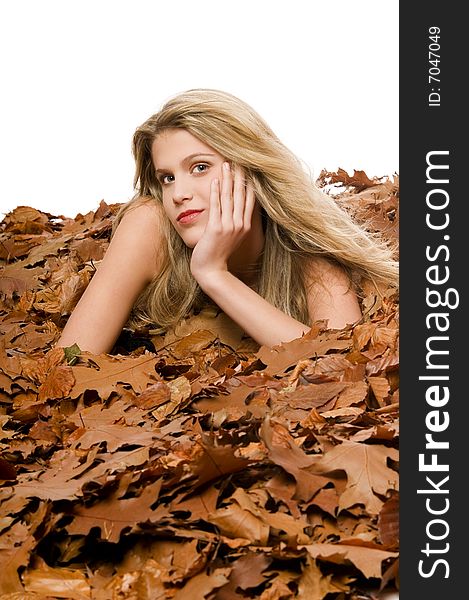 Sexy blond woman lying in autumn leaves on white background