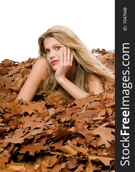 Sexy blond woman lying in autumn leaves