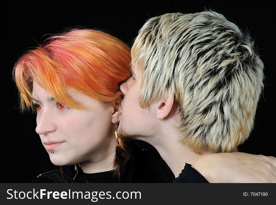 Young guy says soft words to his girlfriend, on black background