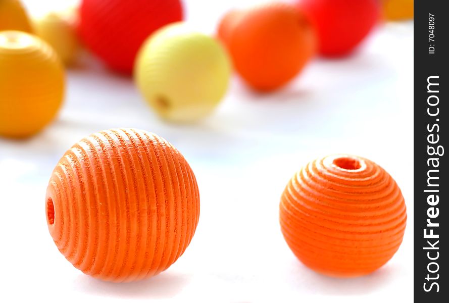 Red. orange and yellow wooden beads on white. Red. orange and yellow wooden beads on white