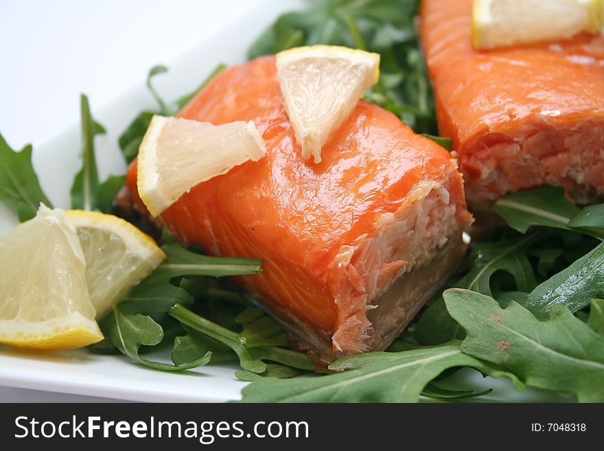 A snack of salmon fish with salad and lemon