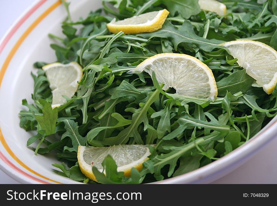 Fresh rucola salad with pieces of lemon