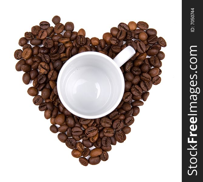 Coffee bean heart made background with cup in the middle. isolated on white background. landscape orientation.