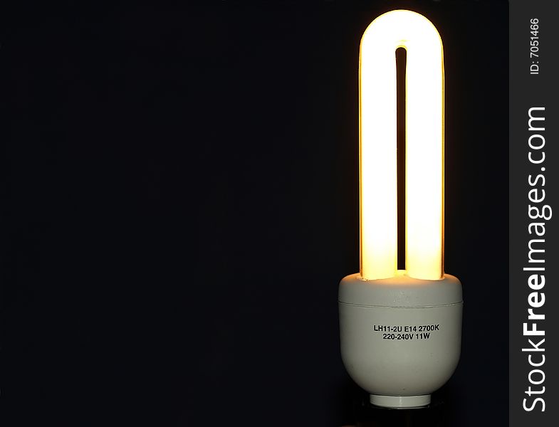 Energy saving light bulb over black background. Energy saving light bulb over black background