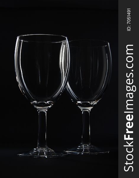 Two empty wine glasses isolated on black background. Two empty wine glasses isolated on black background.