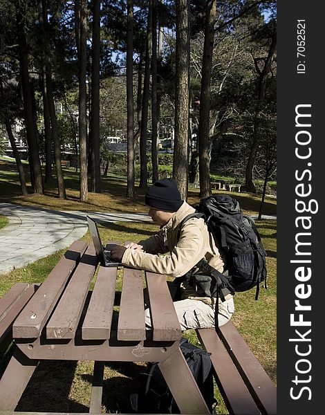 A hiker using a laptop outdoors