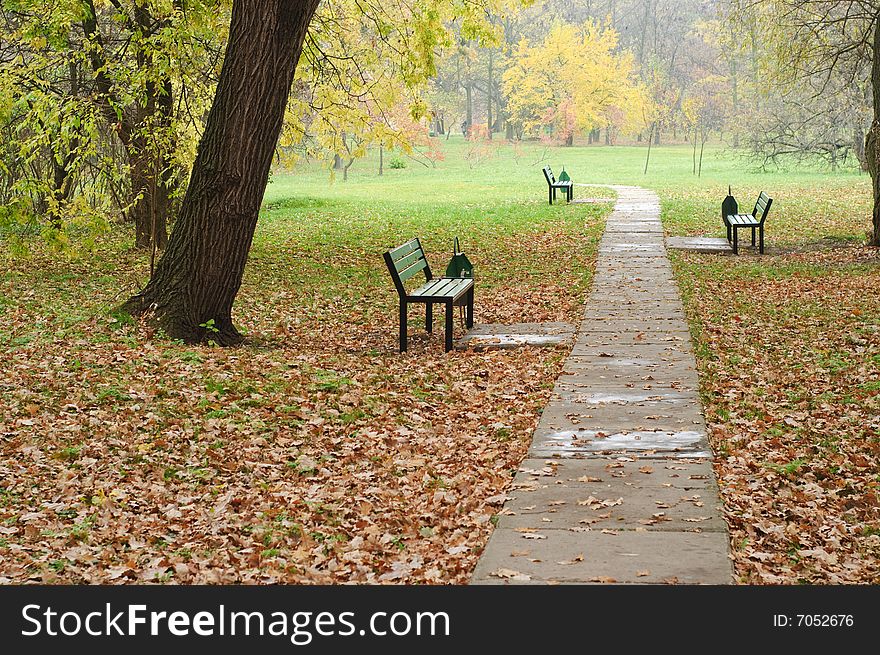 Fall in the park, empty benches near the path