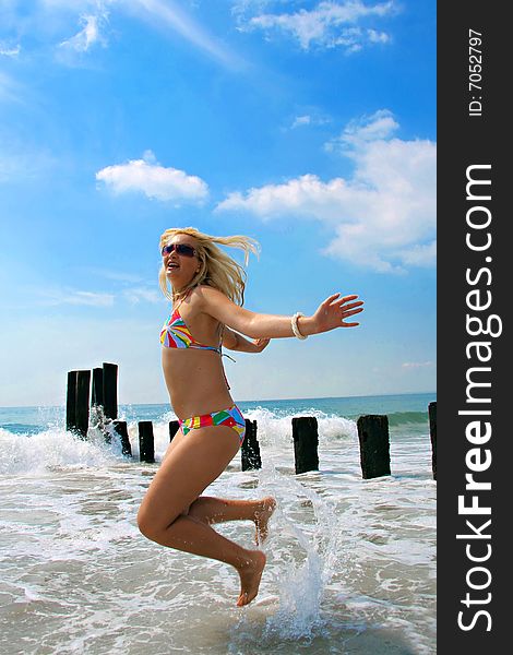 Happy woman jumping on the beach