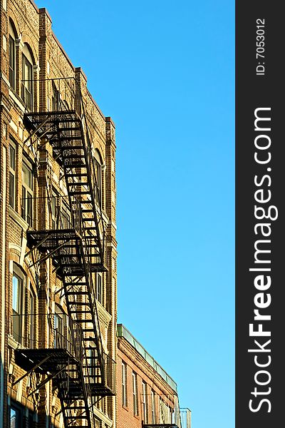 Fire escapes on old tenament buildings in boston massachusetts against a blue sky. Fire escapes on old tenament buildings in boston massachusetts against a blue sky
