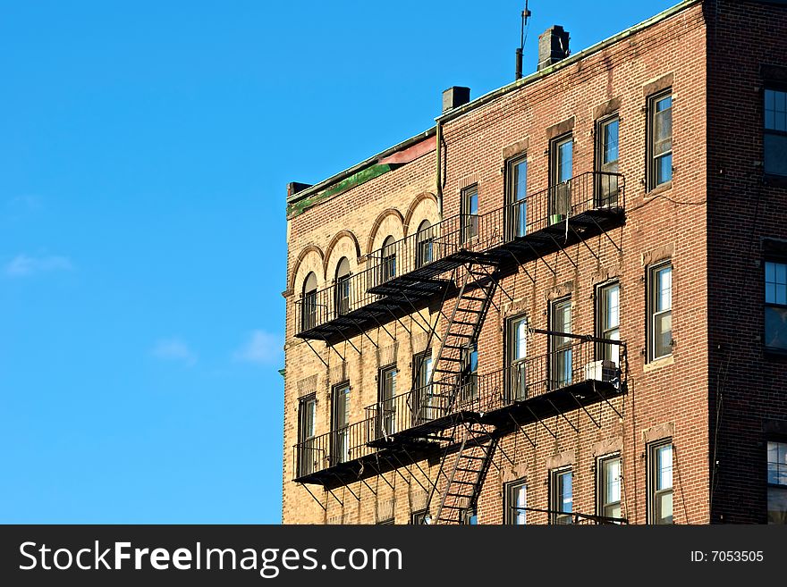 Fire escapes on old tenament buildings in boston massachusetts against a blue sky