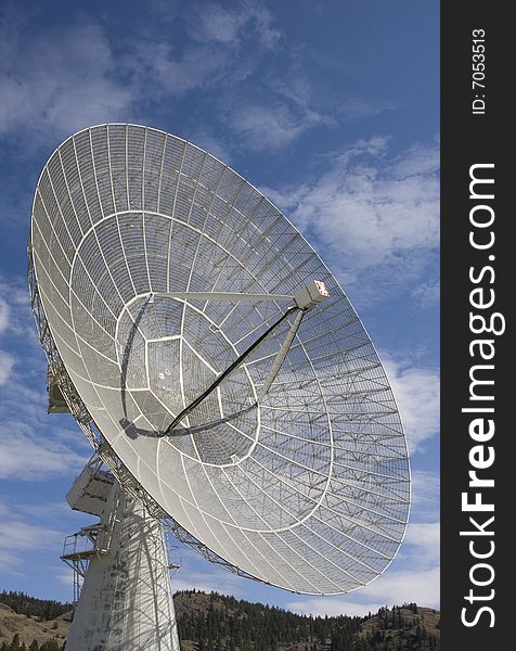 The open weave antenna dish and sturdy base of a large radio telescope.