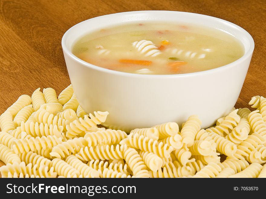 Bowl of chicken soup with pasta and vegetables.