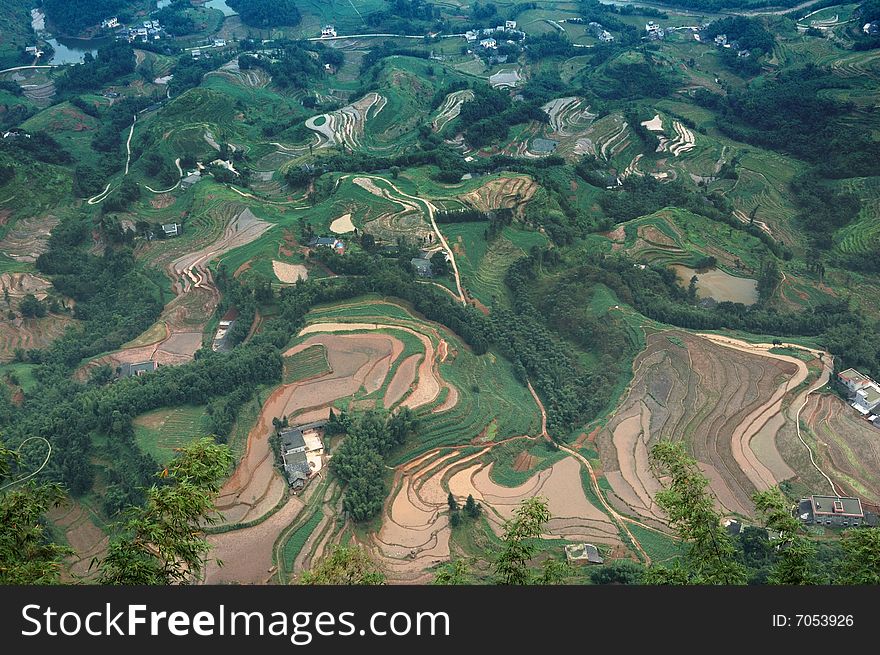 A bird view of house and field from mountain high