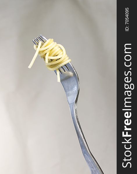 A fork with spaghetti intertwined. Clean background with room for type and graphics. A fork with spaghetti intertwined. Clean background with room for type and graphics.
