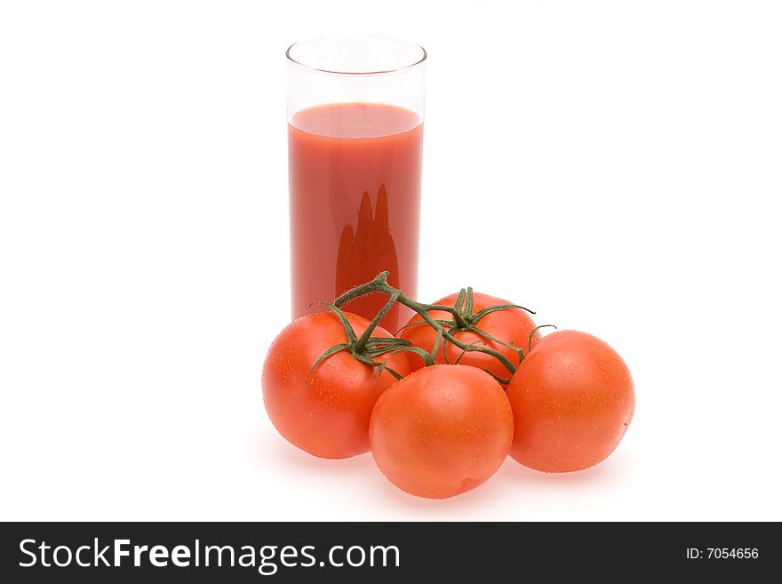 Glass of tomato juice and tomatoes.